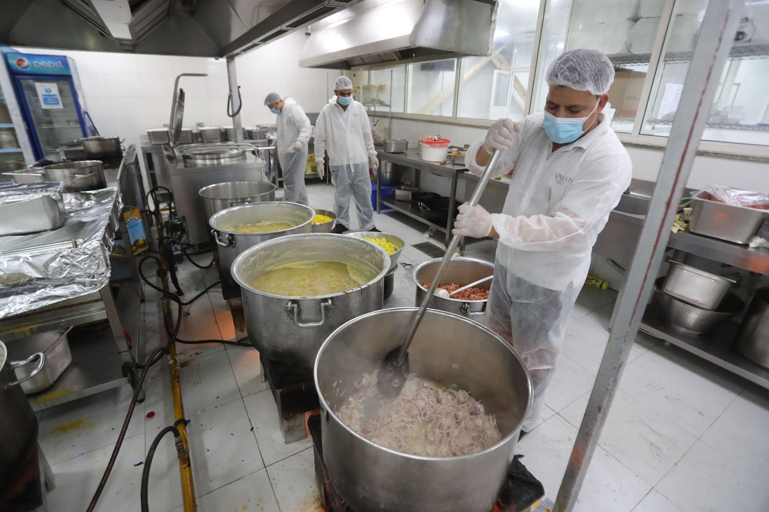 Charity workers preparing food last month for migrant workers under quarantine in Doha. Many migrant workers, who work as security guards, construction workers and janitors, live in squalid camps.