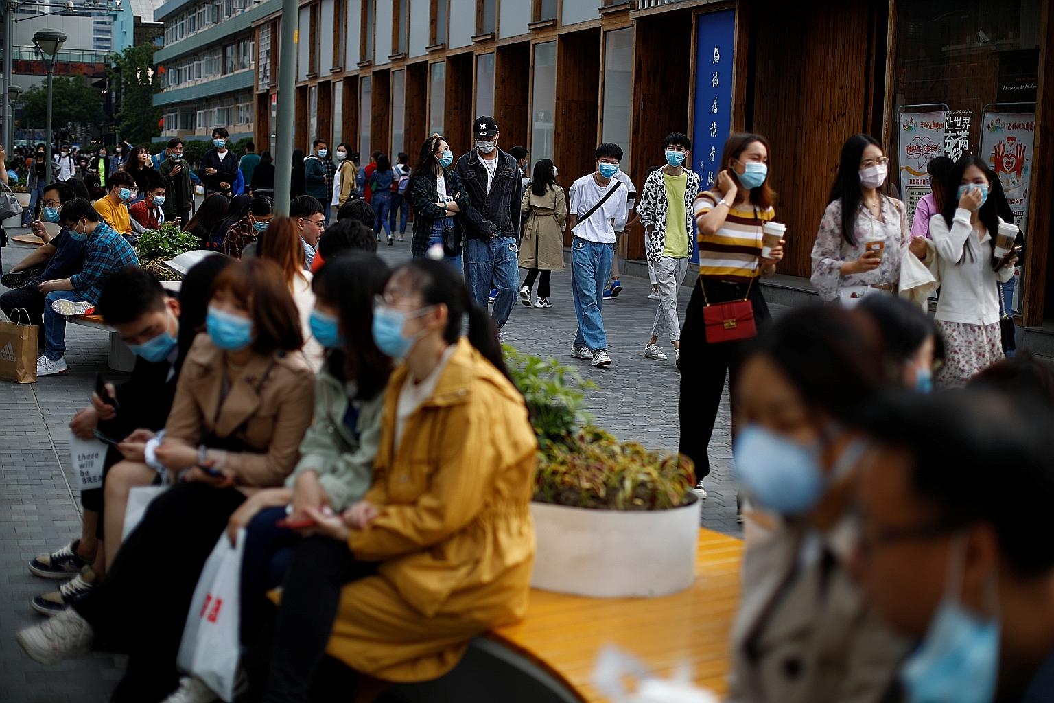 People wearing face masks at a shopping street in Beijing. Countries like China, Japan, South Korea and Singapore have lifted some of the public health and social measures in a slow and controlled way.
