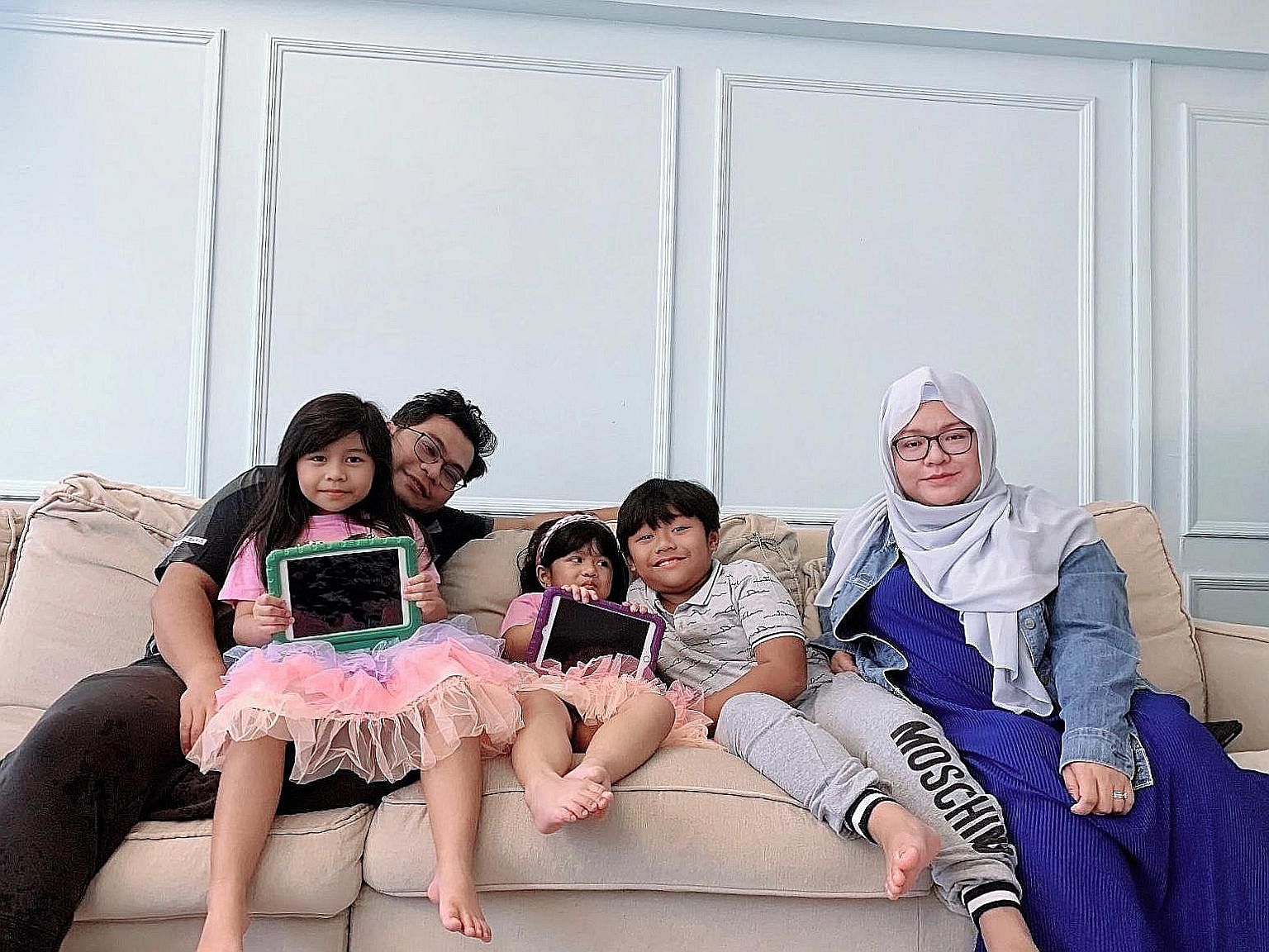 Ms Nur Hafizah Sulaiman’s husband, Mr Mohammed Fariheen Mohamed Faroukh, whose work schedule is more flexible than hers, supervised their children’s home-based learning recently, while she attended to work calls. 