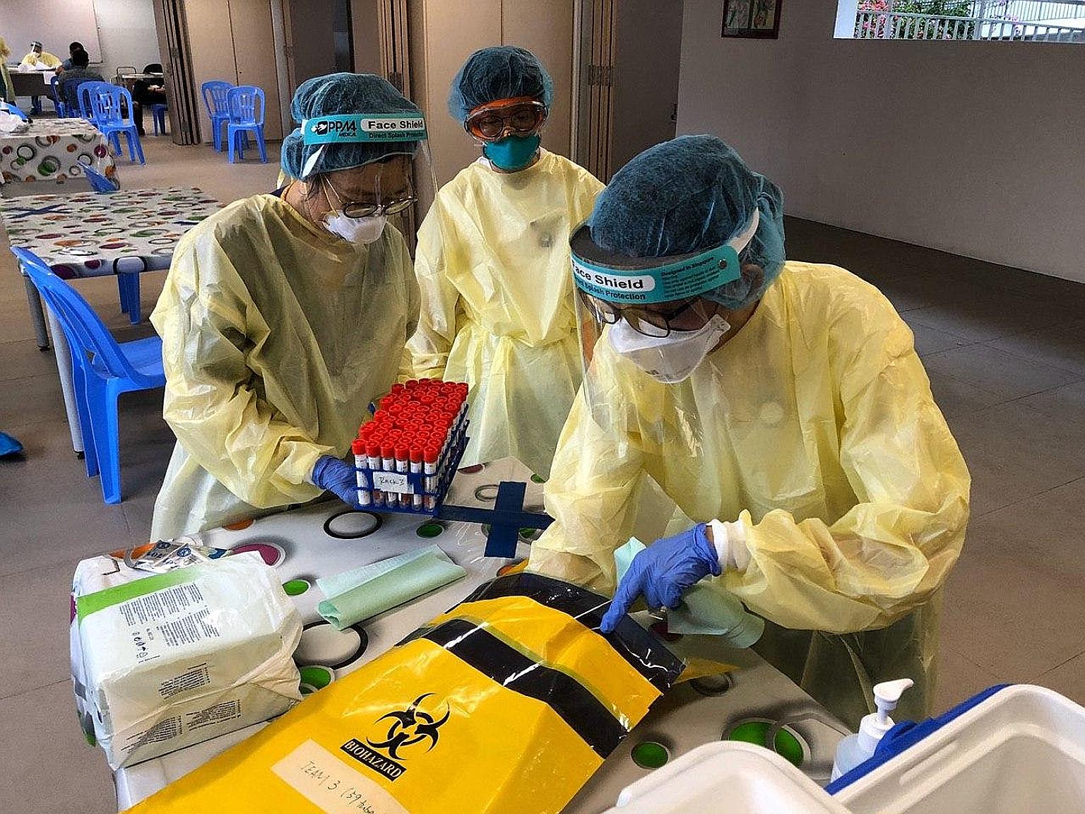 Staff from Khoo Teck Puat Hospital placing swab samples into a bag for transportation.