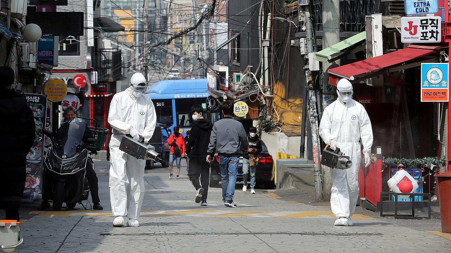 Workers spraying disinfectant in Seoul's Itaewon neighbourhood. A 29-year-old man who went club-hopping with a friend in Itaewon on May 2 tested positive for Covid-19 four days later. The number of cases that has emerged from that cluster shot up to