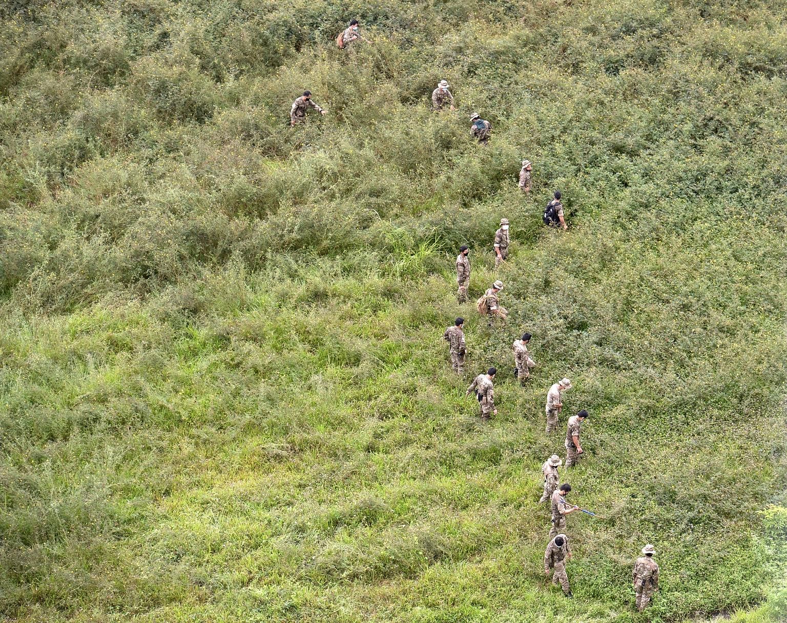 Officers from the police's Gurkha Contingent searching the undeveloped plot of land in Punggol Field, where a 38-year-old man was stabbed on Sunday night. The man later died from his injuries at Sengkang General Hospital. The case has been classified