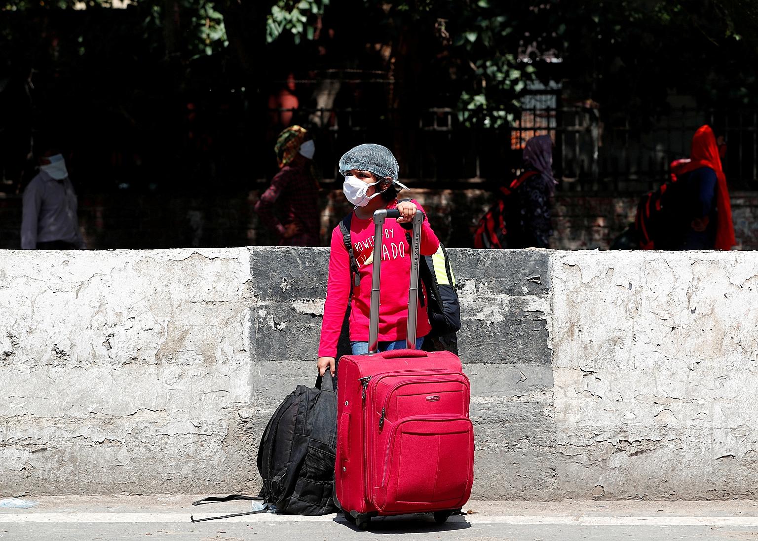 A masked girl outside a New Delhi train station yesterday as India's state-owned railways restarted some services. PHOTO: REUTERS