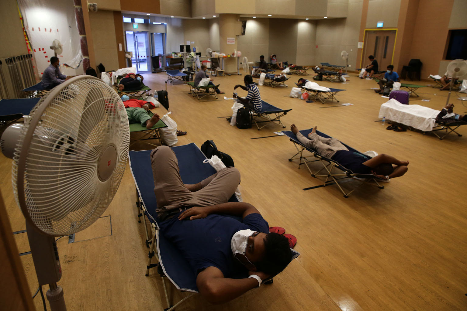 Migrant workers waiting for the results of their swab tests for Covid-19 at Jurong Community Hospital late last month. So far, more than 32,000 foreign workers in dormitories have been tested - about 10 per cent of such workers here. ST PHOTO: KEVIN