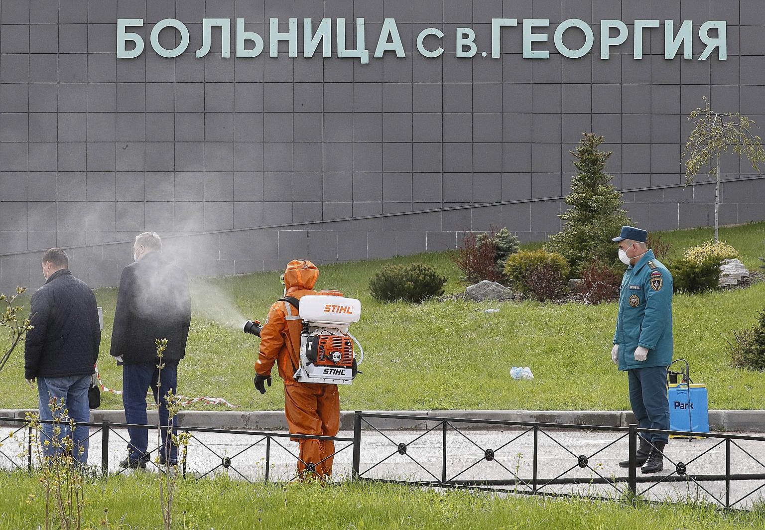 Emergency staff spraying disinfectant in front of the St George City Hospital in St Petersburg, Russia, last month.