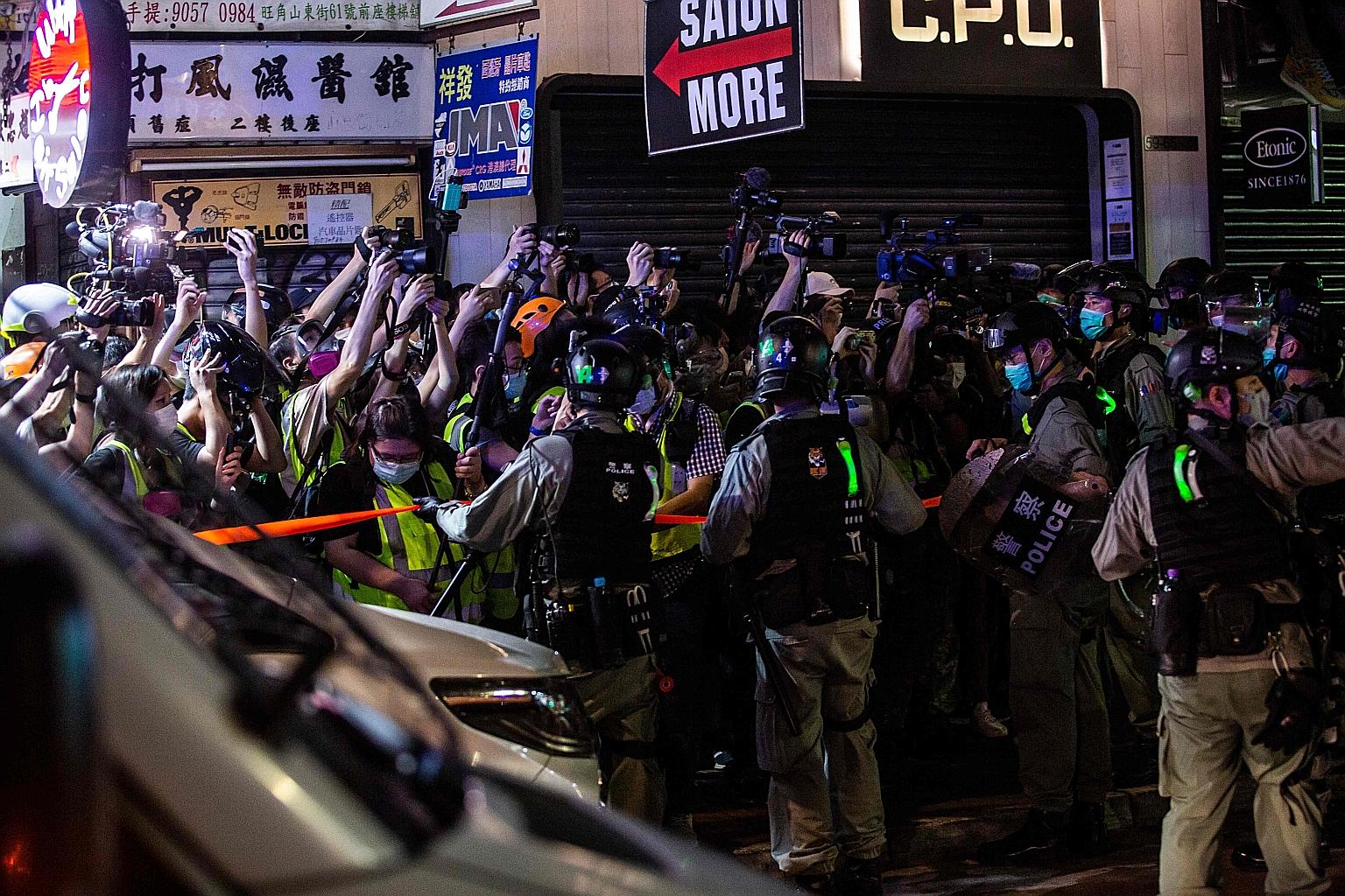 Riot police holding back members of the press during a police operation to arrest pro-democracy demonstrators at a protest calling for the city's independence in Hong Kong's Mong Kok district on Sunday.