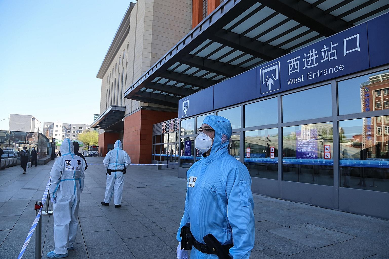 Police officers in protective suits standing guard outside Jilin city's railway station in Jilin province yesterday. The north-eastern city in the province bordering Russia and North Korea has cut off transport links after the emergence of a local co