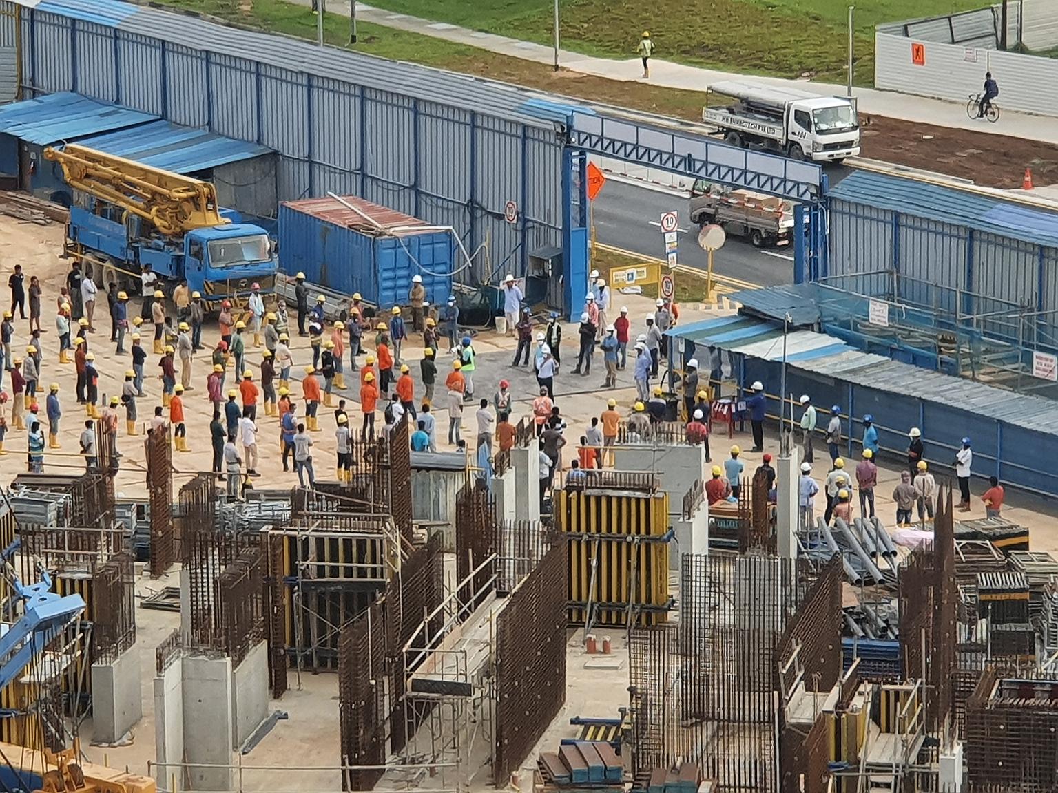 Workers at a construction site in Yishun observing safe distancing during a briefing on April 6. Most construction work was halted when the circuit breaker kicked in the next day. ST PHOTO: YUEN SIN