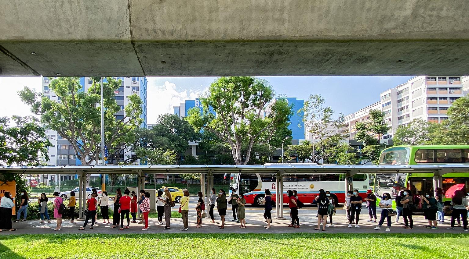 Pre-school staff queueing at Khatib MRT station to board shuttle buses to one of four allocated centres for Covid-19 swab tests on Friday. PHOTO: LIANHE ZAOBAO