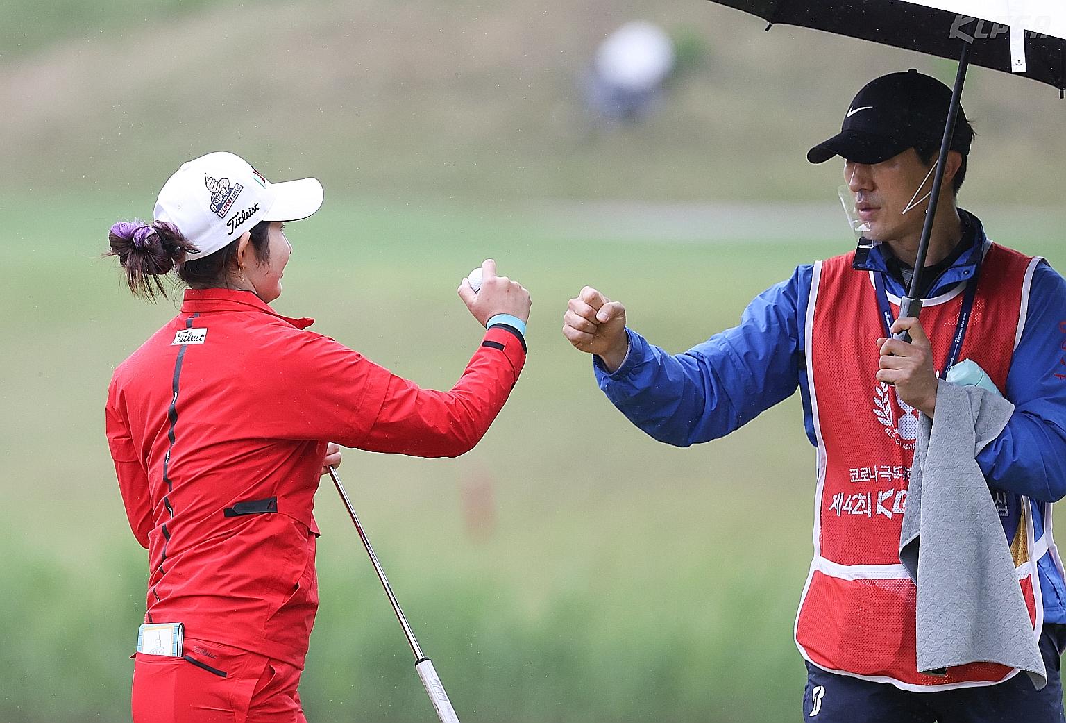 Bae Seon-woo giving her caddie a fist bump on the third day of the KLPGA Championship at Lakewood Country Club in Yangju, South Korea, yesterday. After leading the first two rounds, she shot an even-par 72 and was tied for second with Park Hyun-kyung