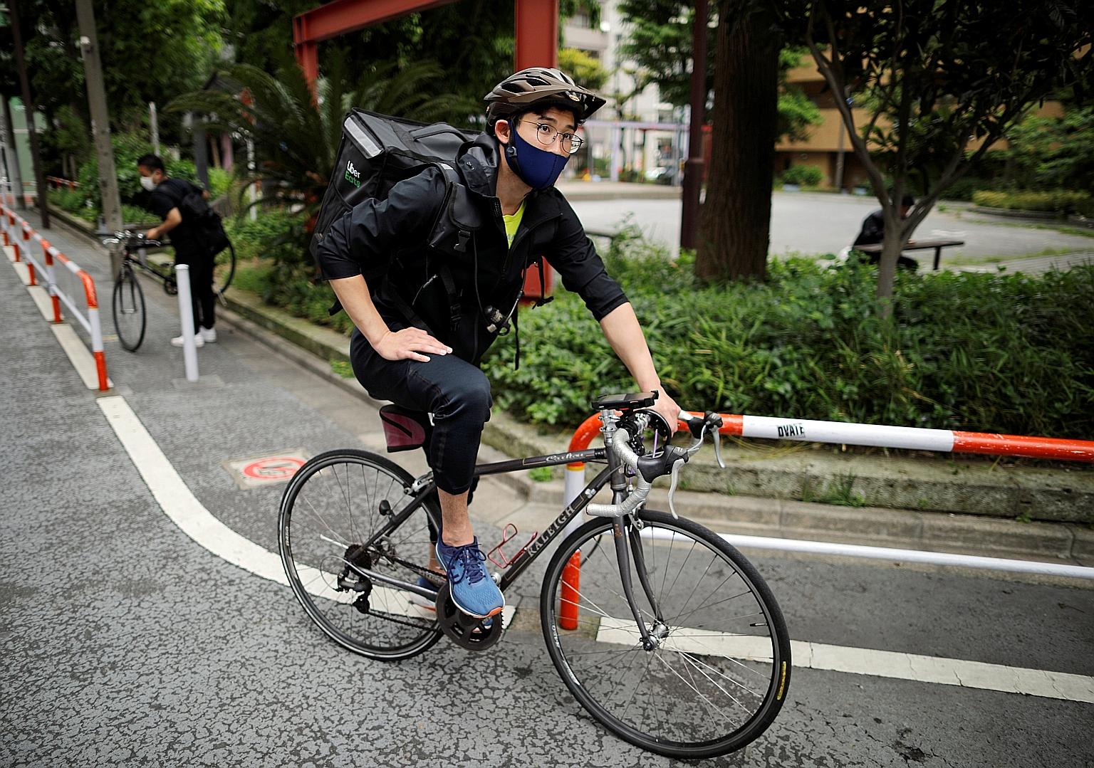 Japan's Olympic fencing medallist Ryo Miyake setting out on another Uber Eats trip around Tokyo last Tuesday amid the coronavirus crisis. His temporary job keeps him in decent financial and physical shape. PHOTO: REUTERS