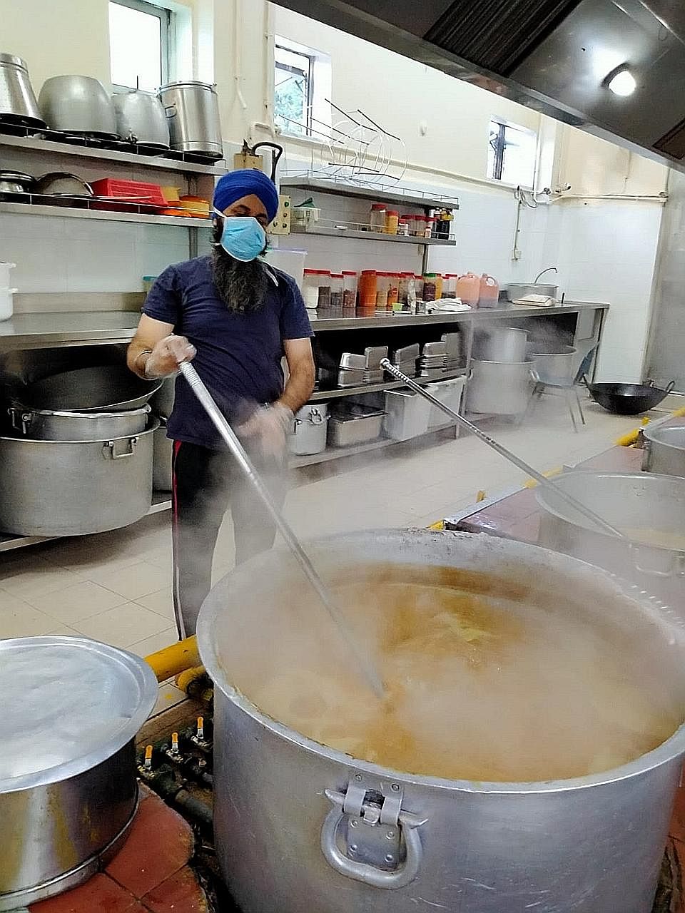 A volunteer preparing a meal under the Sikh community's free kitchen programme.