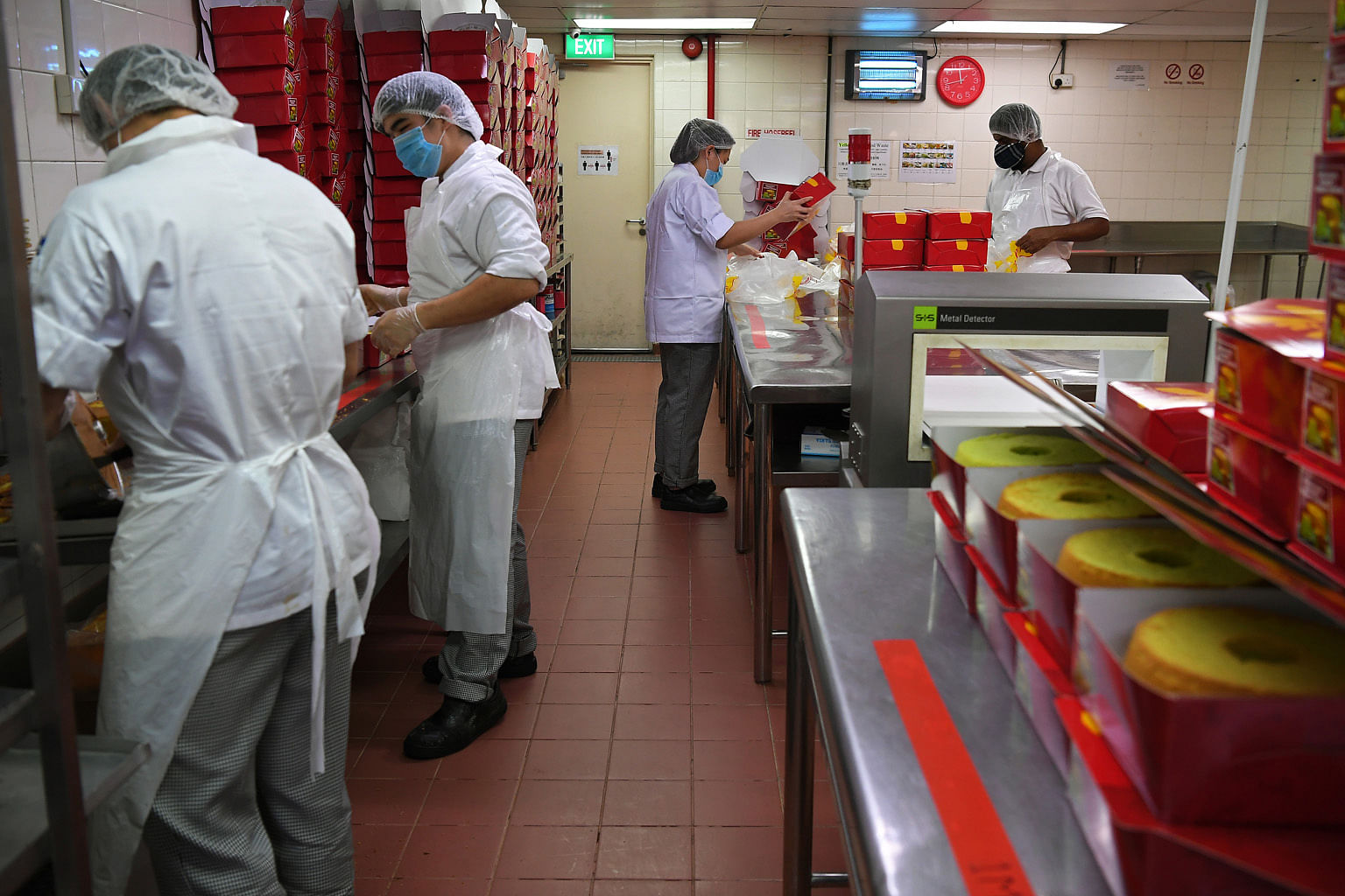 Above: At Shine Precision Engineering in Pioneer, yellow boxes have been marked out next to the large machines to ensure that sufficient distance is kept between employees on the production floor. Cake decorators in confectionery chain Prima Deli's p