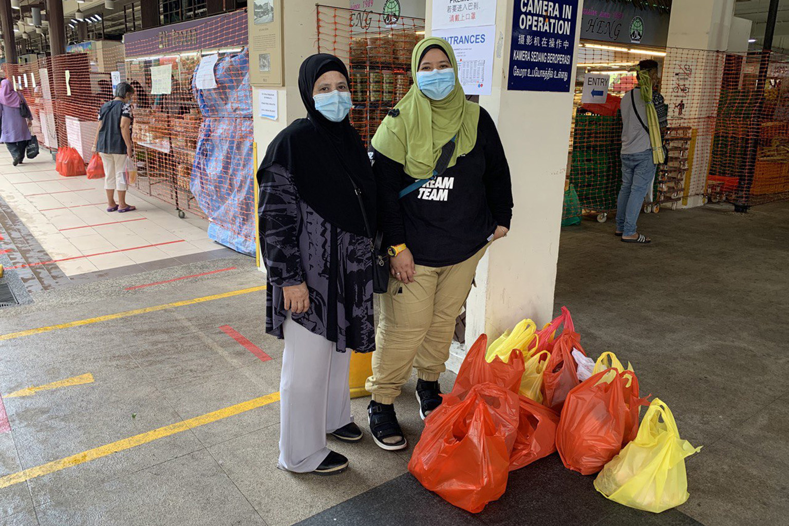 Madam Saodah Mohamad (far left) and her daughter Nashra Nasir at Geylang Serai Market yesterday to do their festive shopping. Madam Saodah will still be cooking her signature dish of sambal goreng pengantin for Hari Raya Aidilfitri although family vi