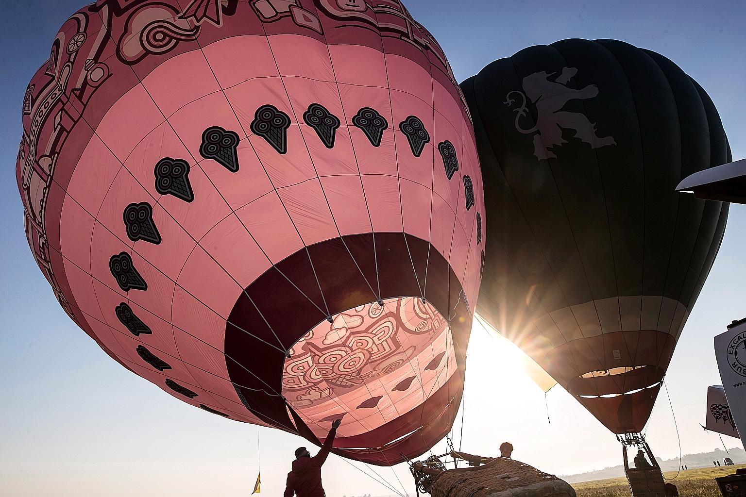 Hot-air balloons at the start of a balloon race as part of celebrations marking the 100th birth anniversary of the late Pope John Paul II, at the Krakow John Paul II International Airport in Krakow, Poland, yesterday. Pope John Paul II was born on Ma