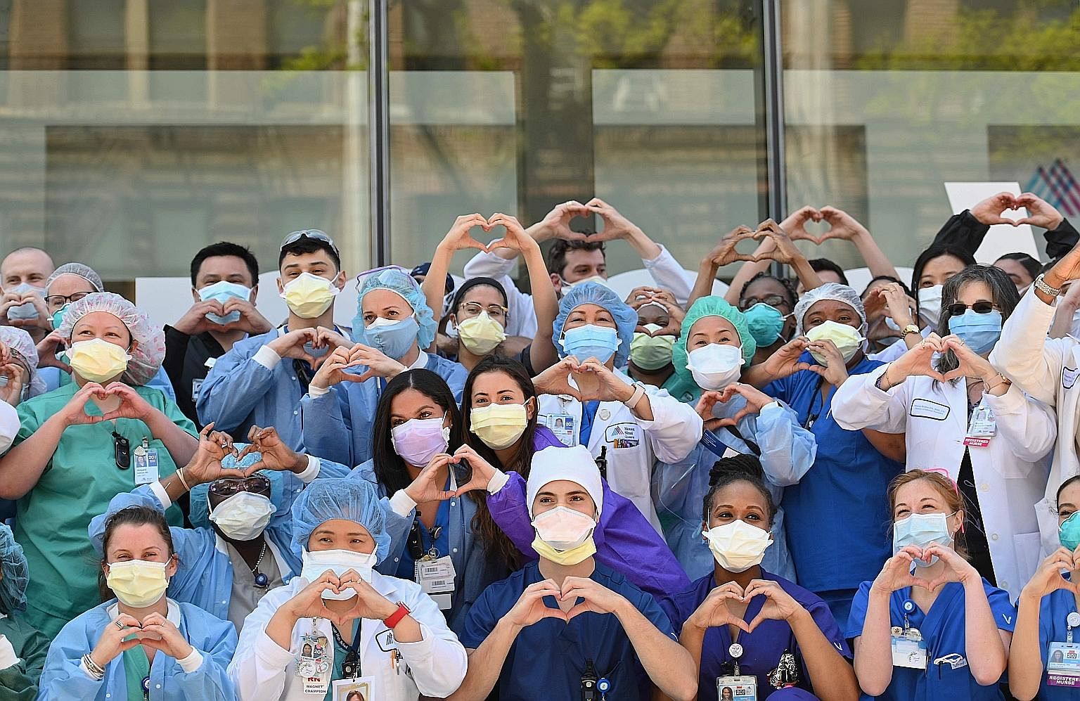 Nurses and healthcare workers gesturing love in celebration of Nurse Week and International Nurses Day outside Mt Sinai Queens in the Queens borough of New York City last Tuesday. ProPublica reported that at least 30 Filipino health workers had died 