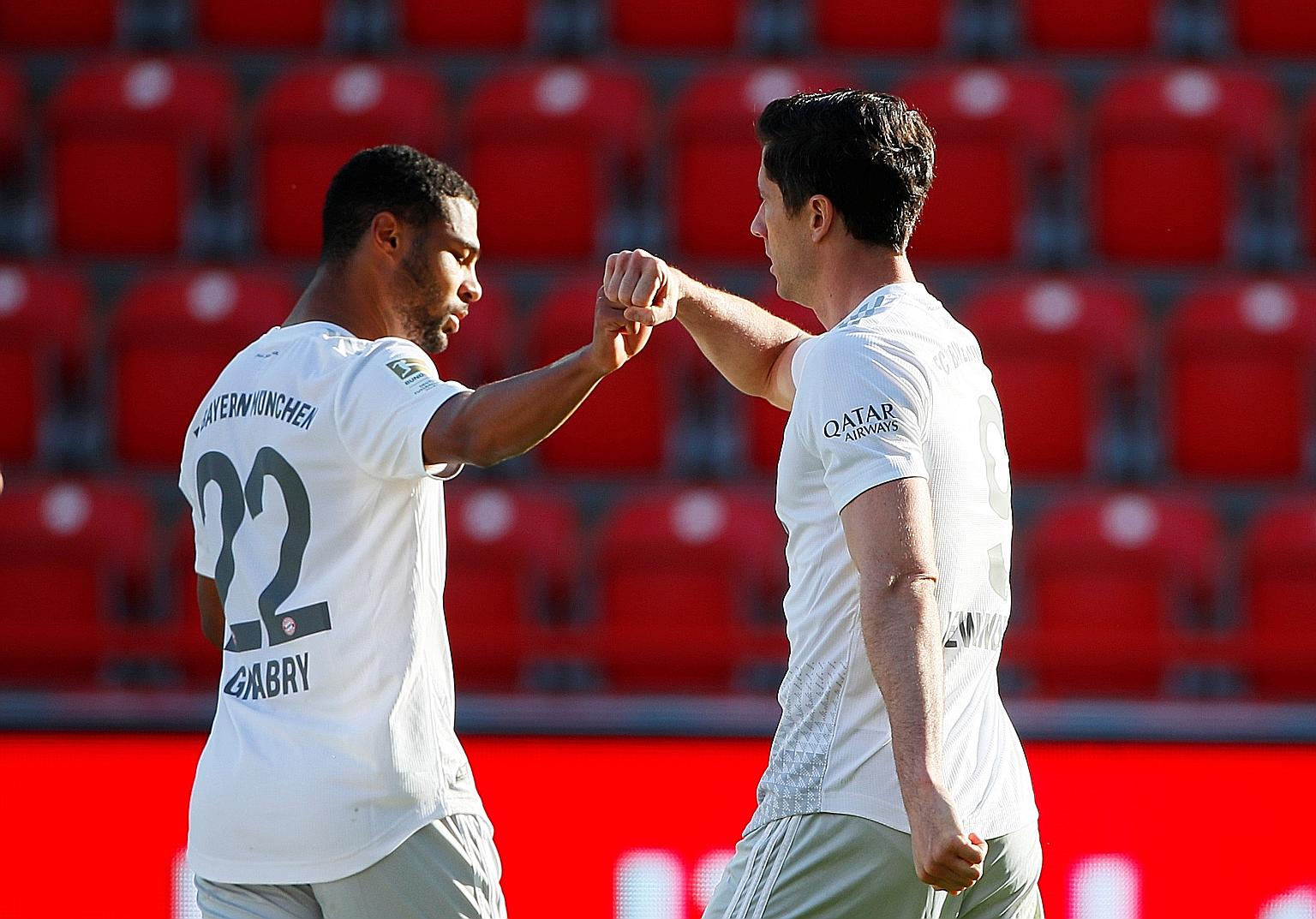Bayern's Polish forward Robert Lewandowski fist bumps German midfielder Serge Gnabry after opening accounts from the spot away to Union Berlin on Sunday. The 28-time Bundesliga champions won 2-0 to restore their four-point lead over Borussia Dortmund