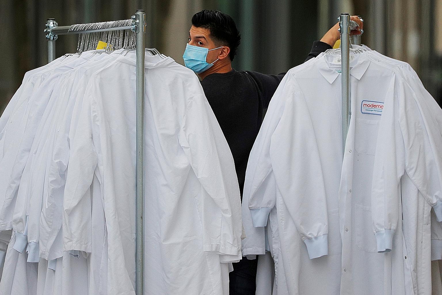 A worker delivering protective lab coats to the headquarters of Moderna, which is developing a vaccine against the coronavirus, in the US state of Massachusetts. The Moderna vaccine is one of more than 100 under development intended to protect agains