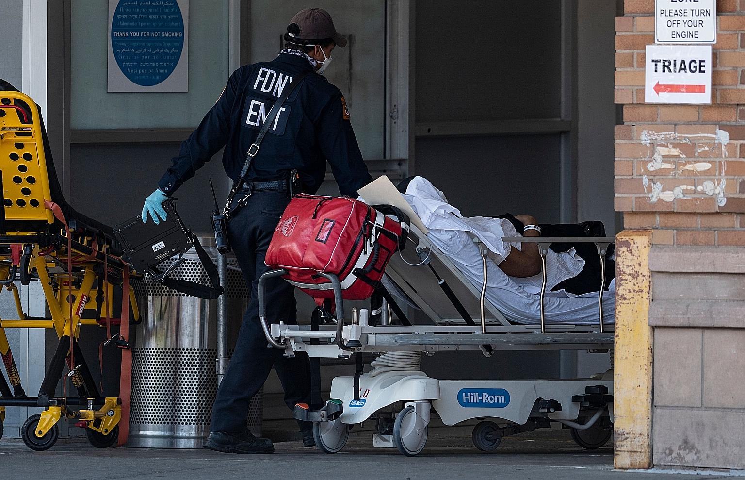 A medical worker wheeling a patient into a special Covid-19 illness area last Sunday at Maimonides Medical Centre in Brooklyn, New York City. Coronavirus-related deaths among Americans are projected to surpass 113,000 by mid-June.