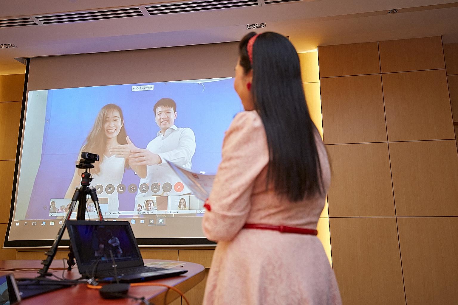 Ms Lim Ding Yi and Mr Jeremy Gan participating in their solemnisation in their new home in West Coast, while their solemniser Joanna Portilla was based in Thomson. PHOTO: MINISTRY OF SOCIAL AND FAMILY DEVELOPMENT