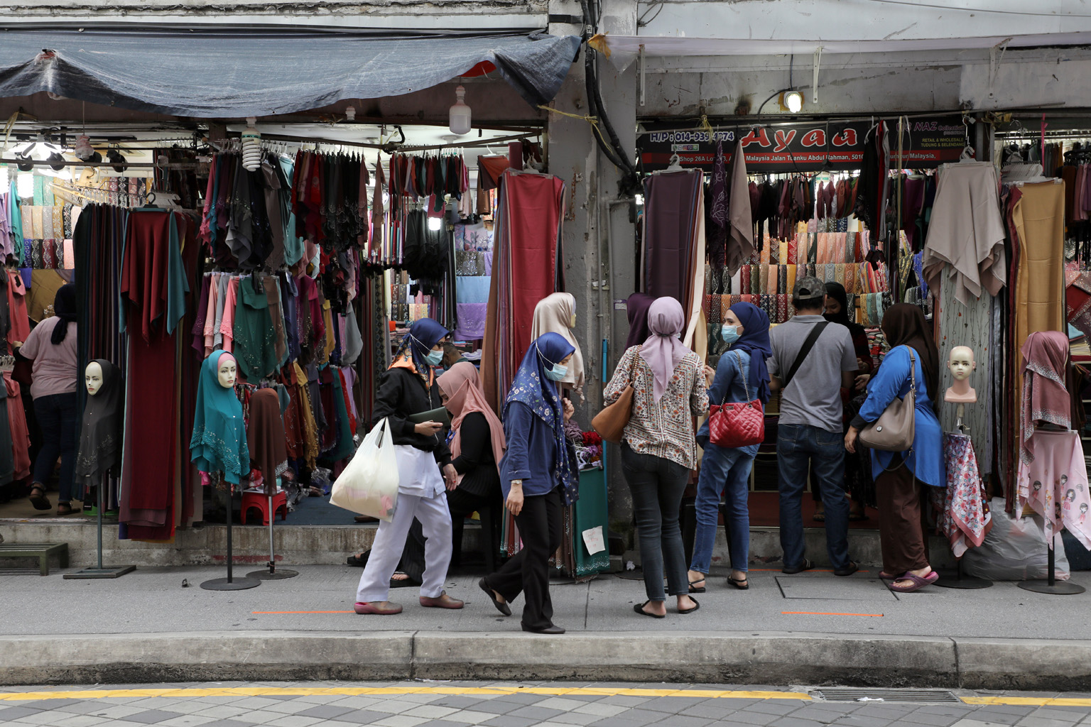 Malaysians shopping in Kuala Lumpur yesterday. Malaysia eased controls on May 4, allowing most businesses to reopen. But large gatherings are still banned. PHOTO: REUTERS Italians having coffee on the terrace of an eatery in Rome yesterday. Italy's b