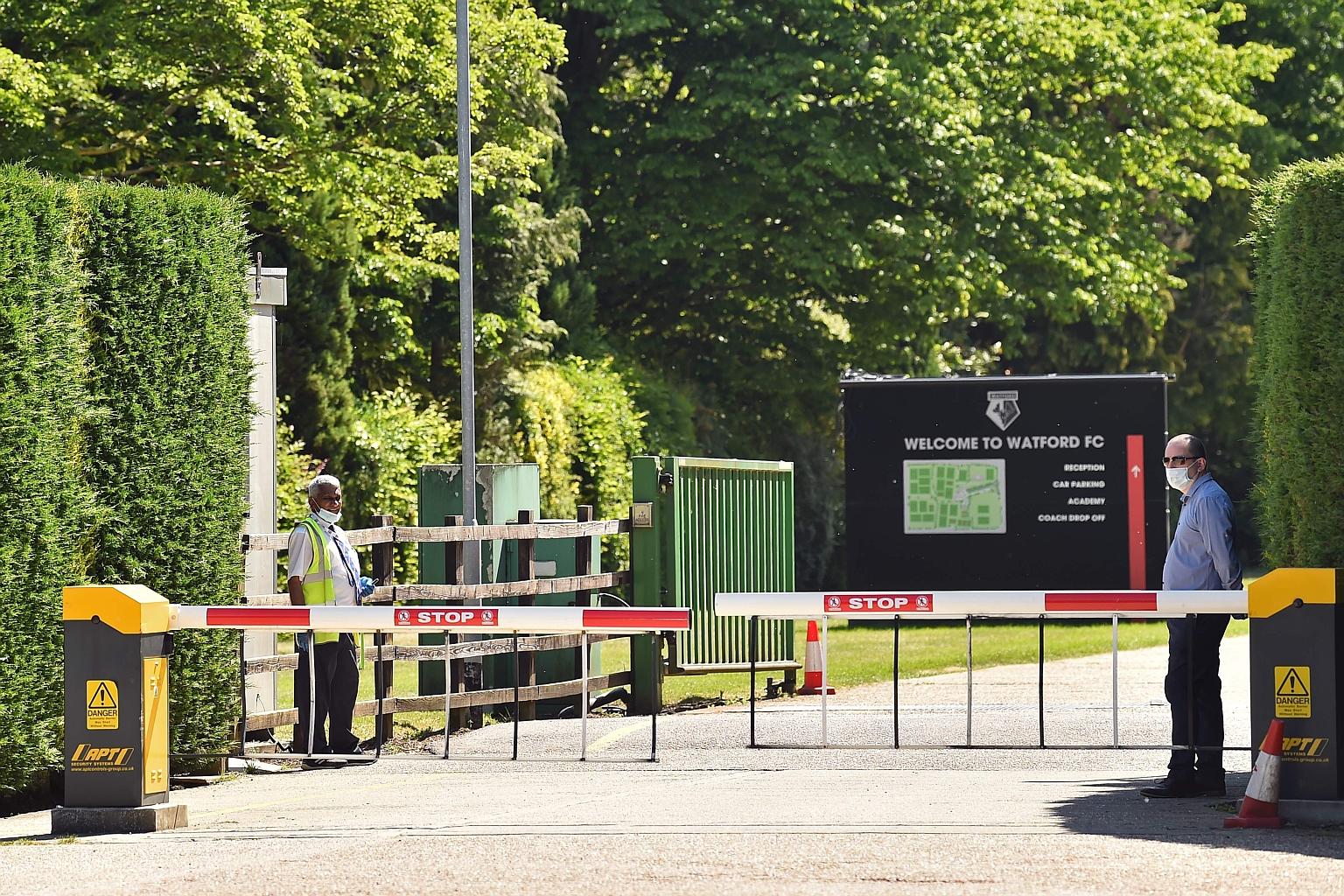Security guards wearing personal protective equipment manning a gate at Watford's training facility at London Colney.