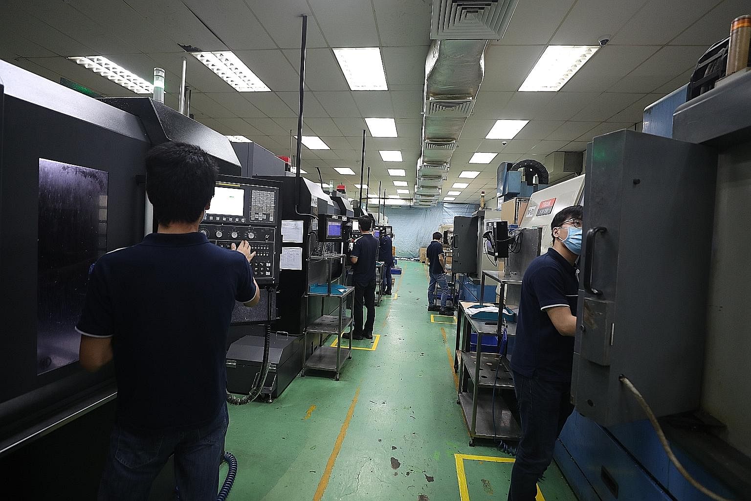Safe distancing measures in place at Shine Precision Engineering. Social distancing and contact tracing are likely to be a big part of the day-to-day operations in firms for the long haul, says the writer. ST PHOTO: TIMOTHY DAVID