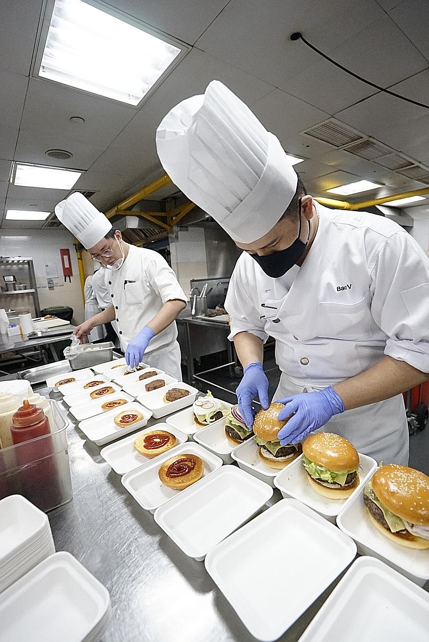 Grand Hyatt Singapore chefs preparing free burgers for F&B employees as part of the Together In Spirits campaign. EuroCham reimburses eateries $20 a meal to cover preparation and delivery costs.