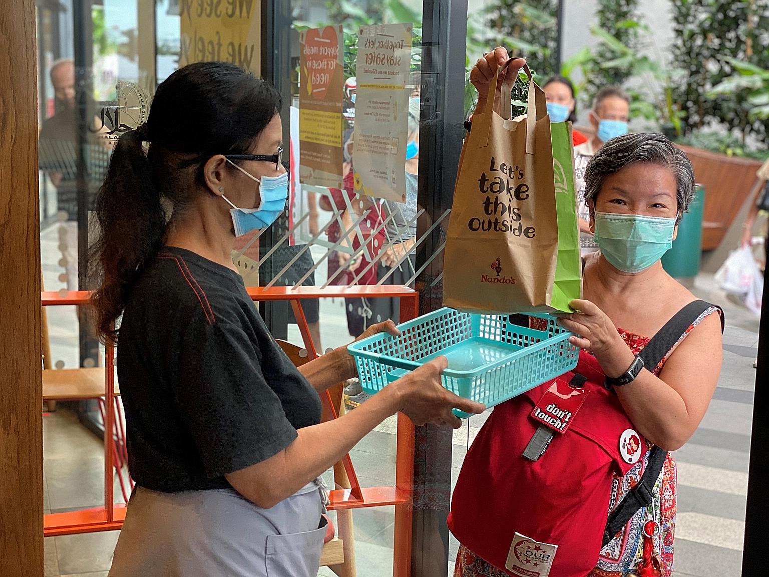 A beneficiary receiving a meal from restaurant chain Nando's. The 300 free meals daily are available at six outlets till next week.