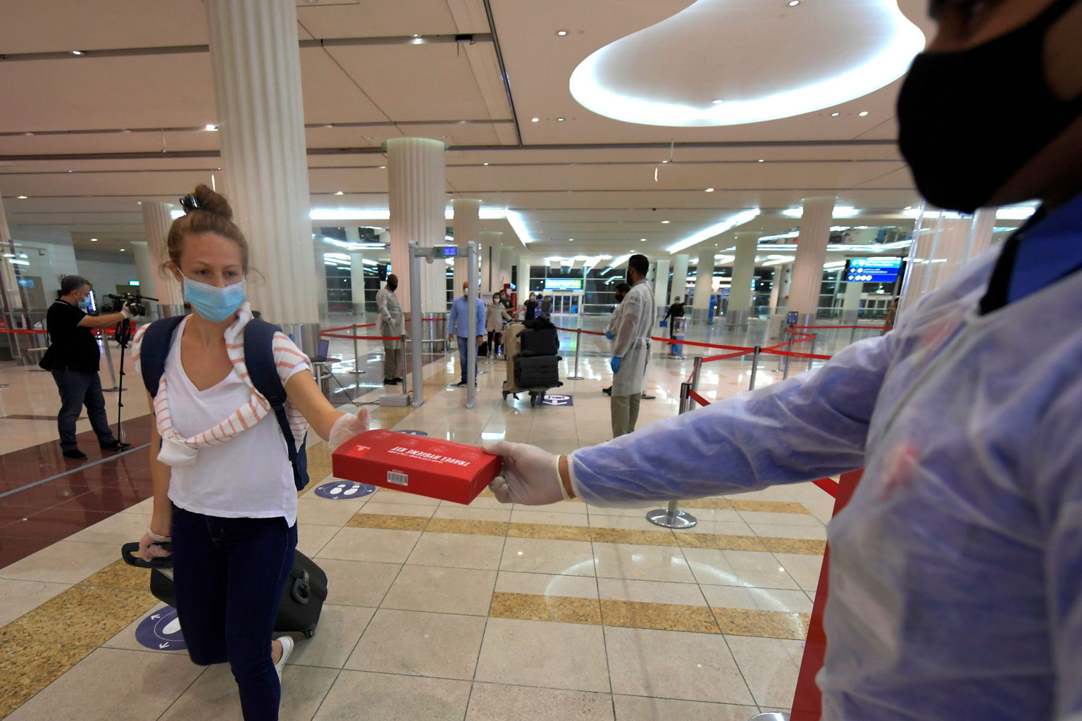 An Emirates passenger receiving a box of masks and gloves at Dubai airport on Friday. Observers say the industry is looking at a time lag of three years at least before business returns to pre-Covid days.