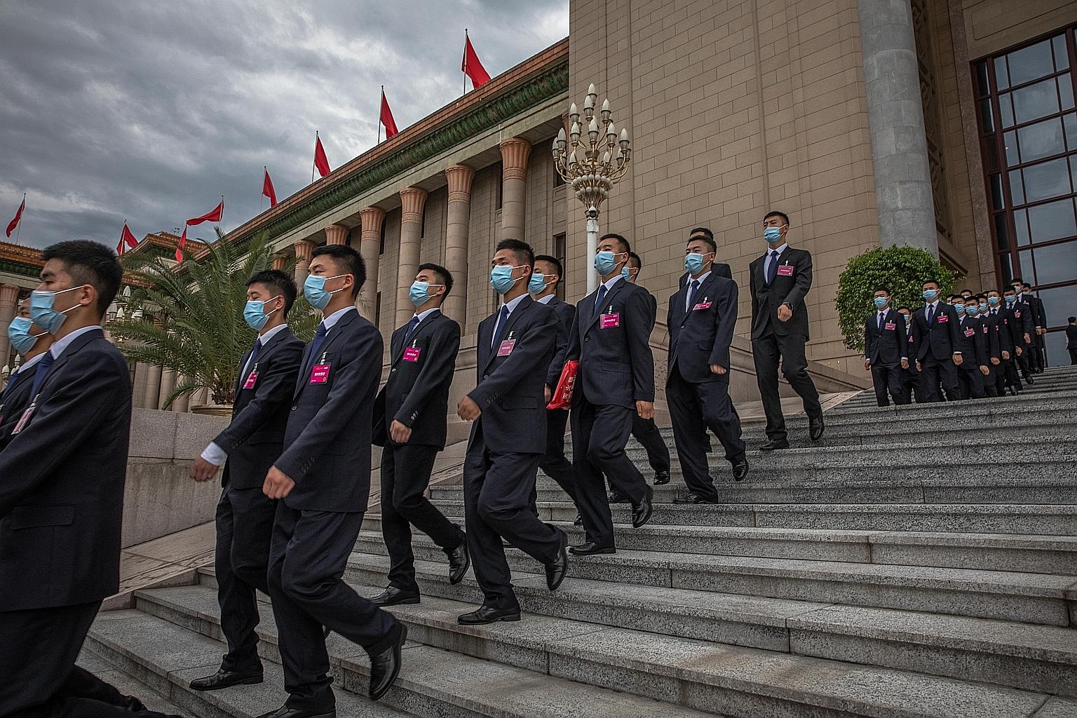 Security officials marching after the second plenary session of China's National People's Congress at the Great Hall of the People in Beijing, where the country's top prosecution body presented its annual report yesterday.