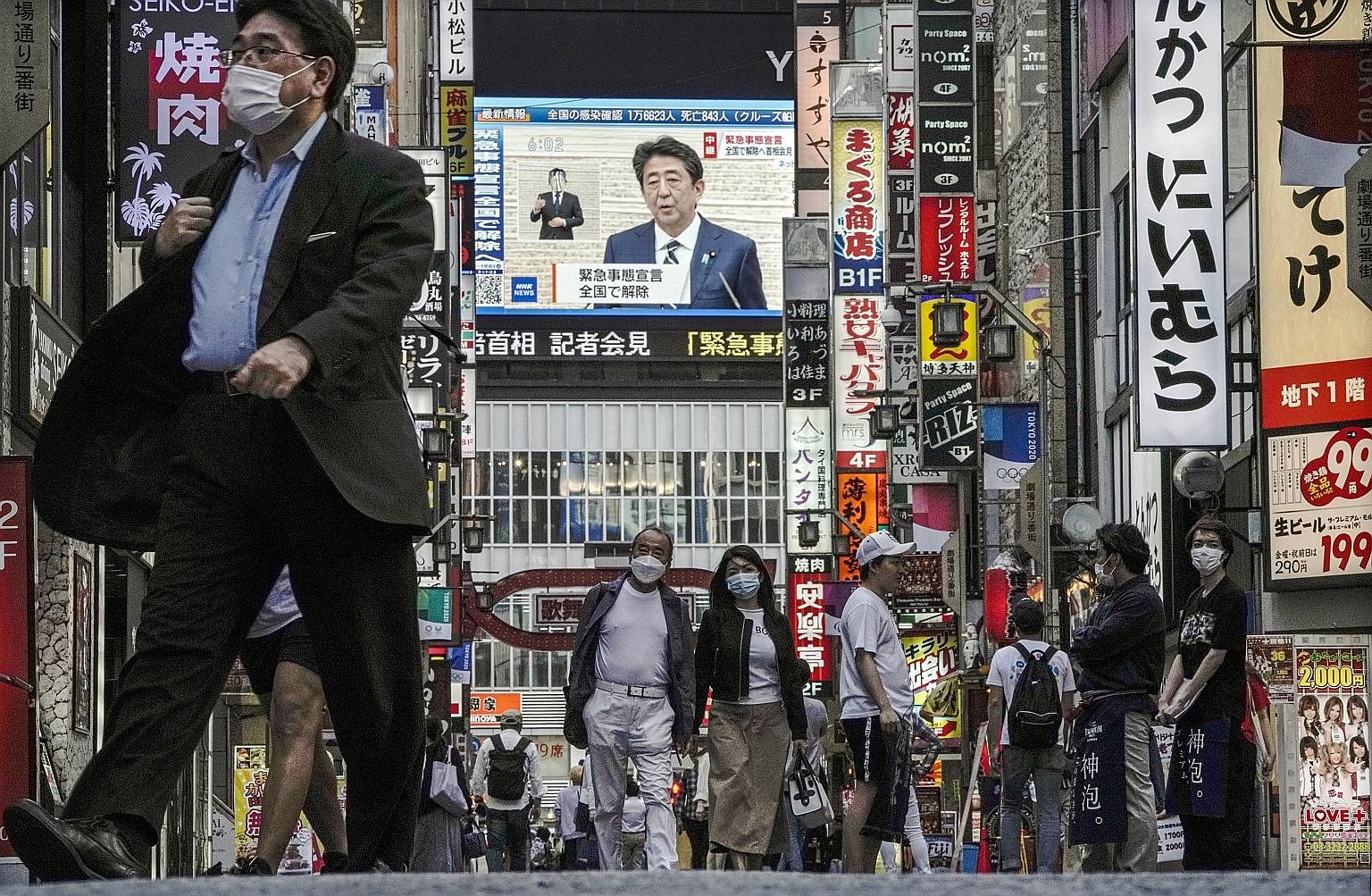 Japanese Prime Minister Shinzo Abe announced the end of a nationwide state of emergency in a live TV broadcast yesterday - seen here in Tokyo's Shinjuku area - as the number of coronavirus cases tailed off. He also announced plans for a second aid pa