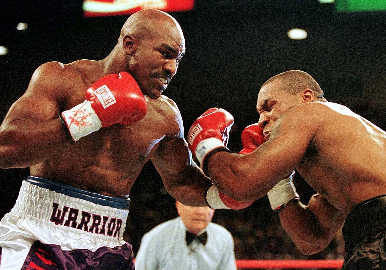 Evander Holyfield connecting with a left in his heavyweight bout against Mike Tyson in 1997, which was notoriously known as 'The Bite Fight' after the latter was disqualified for biting off a chunk of his opponent's ear.
