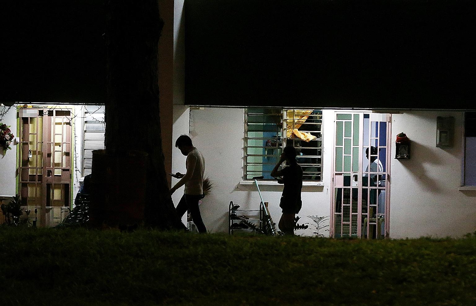 A Straits Times journalist at a block in Boon Lay being led by a man (left) to a flat where a Thai card game was to be played. Two men had watched to ensure the journalist was alone before they brought her up to the unit. She left before the session 