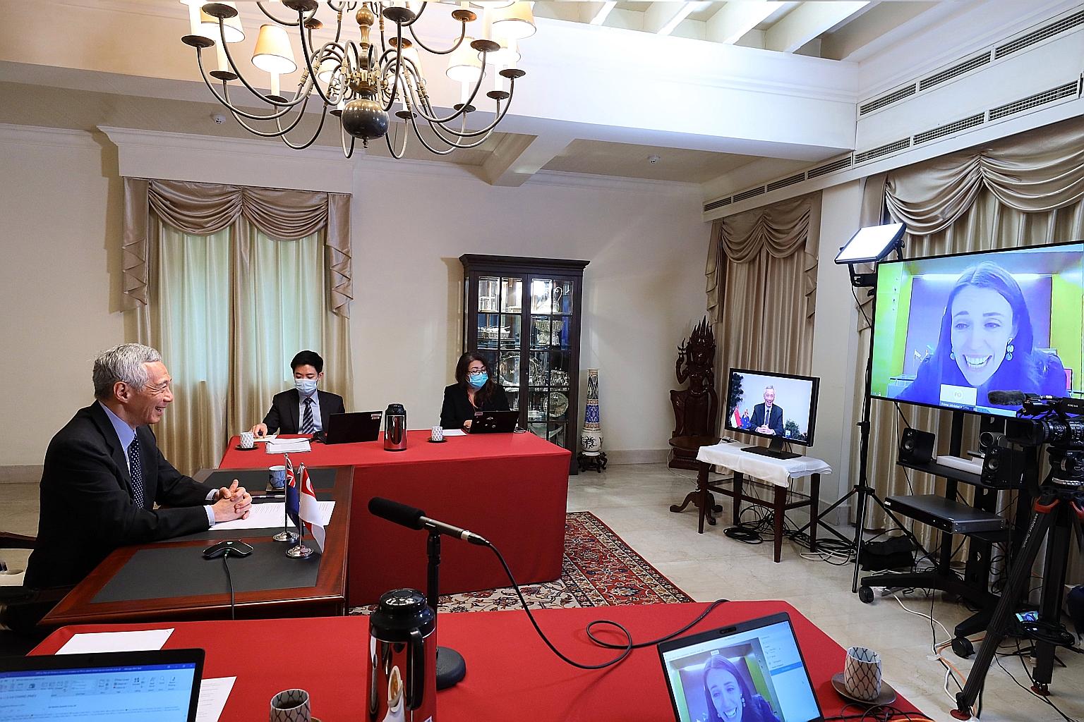 Prime Minister Lee Hsien Loong having a virtual meeting with New Zealand Premier Jacinda Ardern yesterday. PHOTO: MINISTRY OF COMMUNICATIONS AND INFORMATION