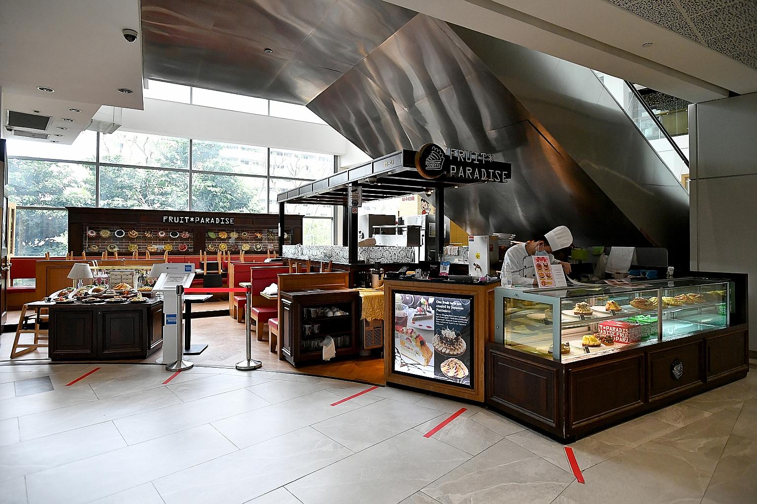 Red tape pasted on the floor as part of safe distancing measures at Fruit Paradise cafe at AMK Hub. The new regulations will mean that if a household of more than five people wants to dine in at an eatery, they will have to sit at separate tables.