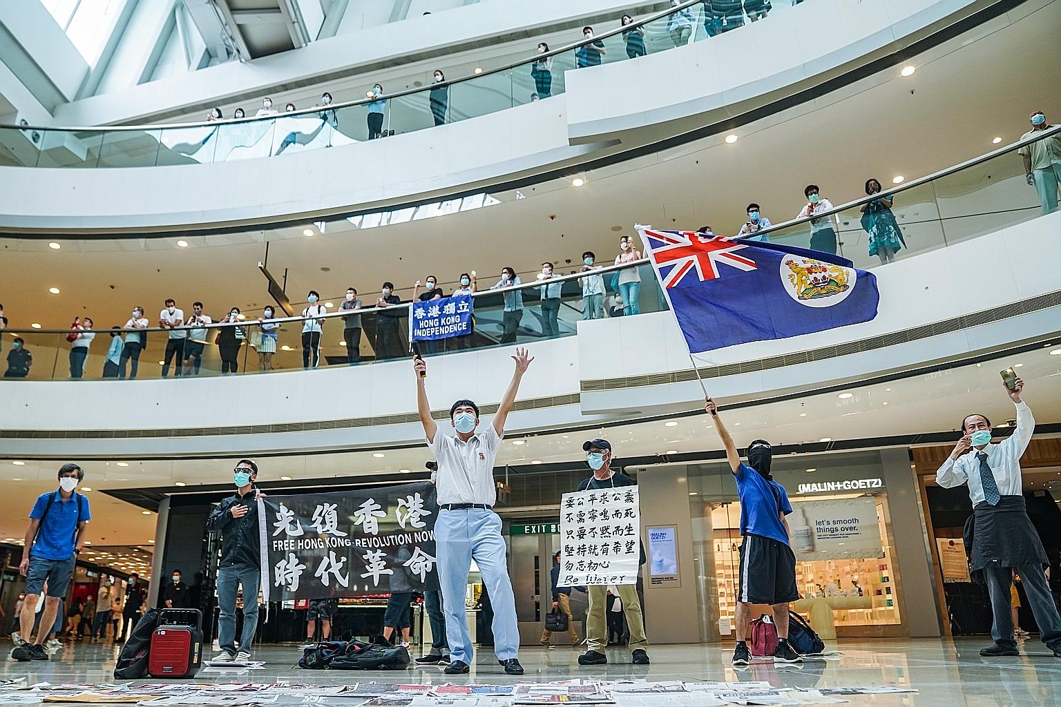 A demonstrator waving a colonial-era Hong Kong flag during a lunchtime protest at the International Finance Centre mall in Hong Kong yesterday.
