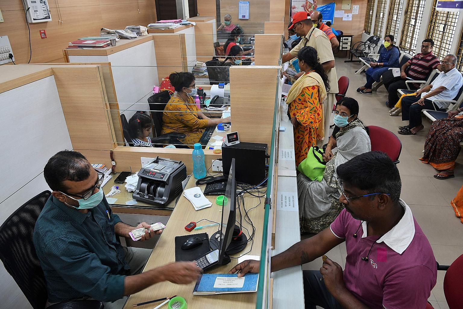 Bank clerks wearing masks amid concerns over the spread of coronavirus in a Bangalore bank earlier this year. With India's lockdown on March 24, global banks are concerned as call centres and other units are effectively closed, leading to a scrutiny