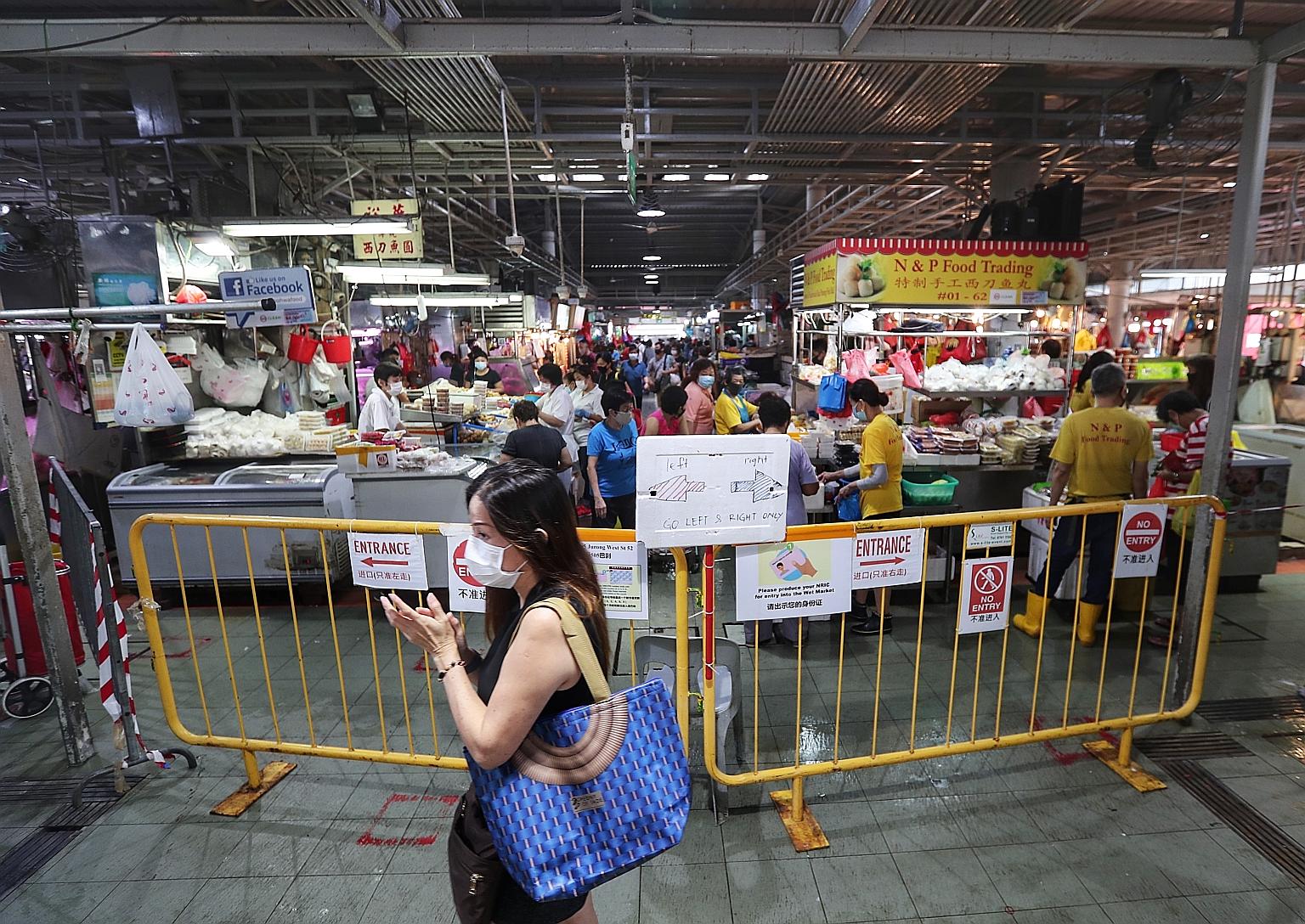 Odd-or even-date entry restrictions at four popular markets, including the one at Block 505 Jurong West Street 52 (left), will continue, although NEA said the crowd situation at these markets has eased significantly over the last five weeks.
