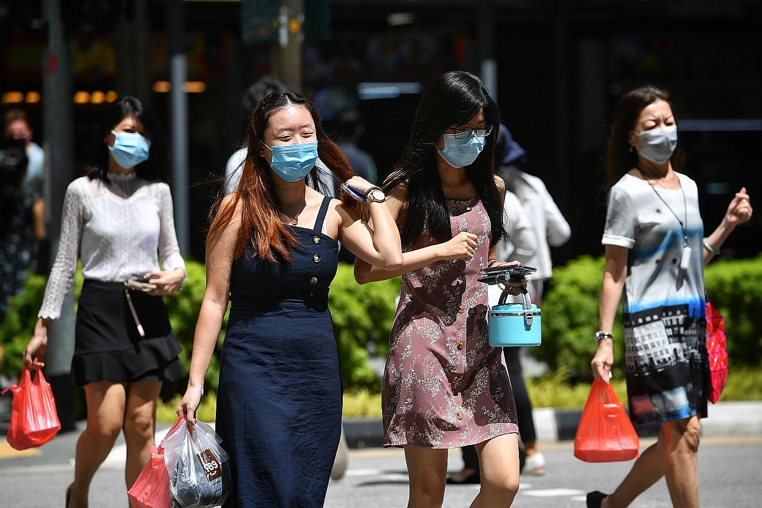 Covid-19 restrictions such as safe distancing and the wearing of masks are likely to remain until a vaccine or treatment is developed, said National Development Minister Lawrence Wong. ST PHOTO: CHONG JUN LIANG
