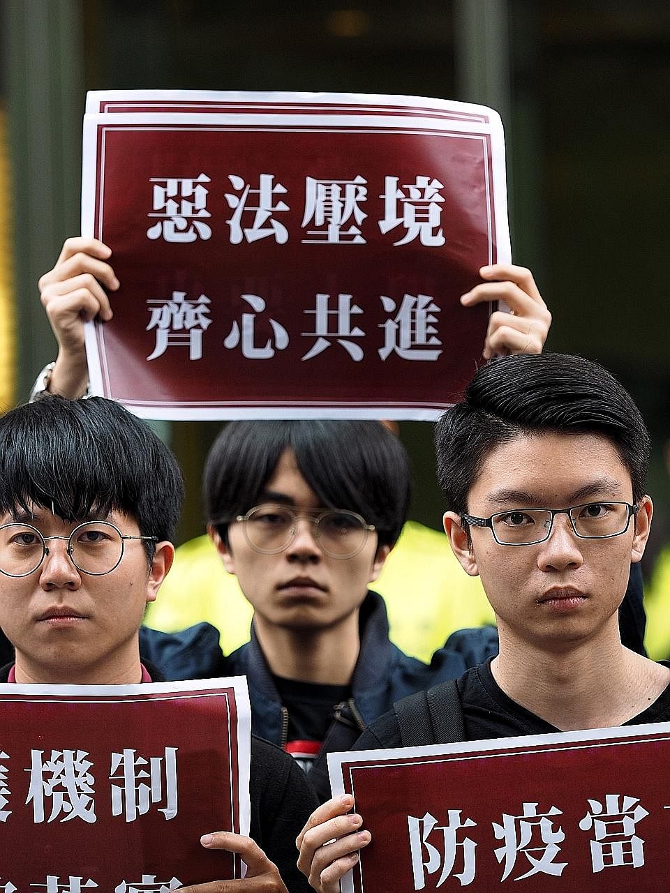 Far right: Hong Kong Chief Executive Carrie Lam at a press briefing in Beijing yesterday. She was in the Chinese capital to discuss Hong Kong's new security legislation. Right: Members of civic groups in Taiwan holding signs that said "The national s