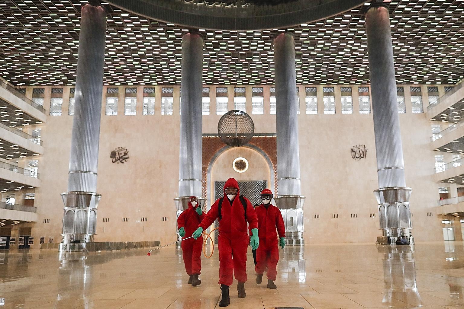 Disinfectant being sprayed at Istiqlal Mosque in Jakarta on Wednesday. Places of worship in the Indonesian capital can open their doors from today, as part of a transition phase over the next few weeks. The city administration can reinstate restricti