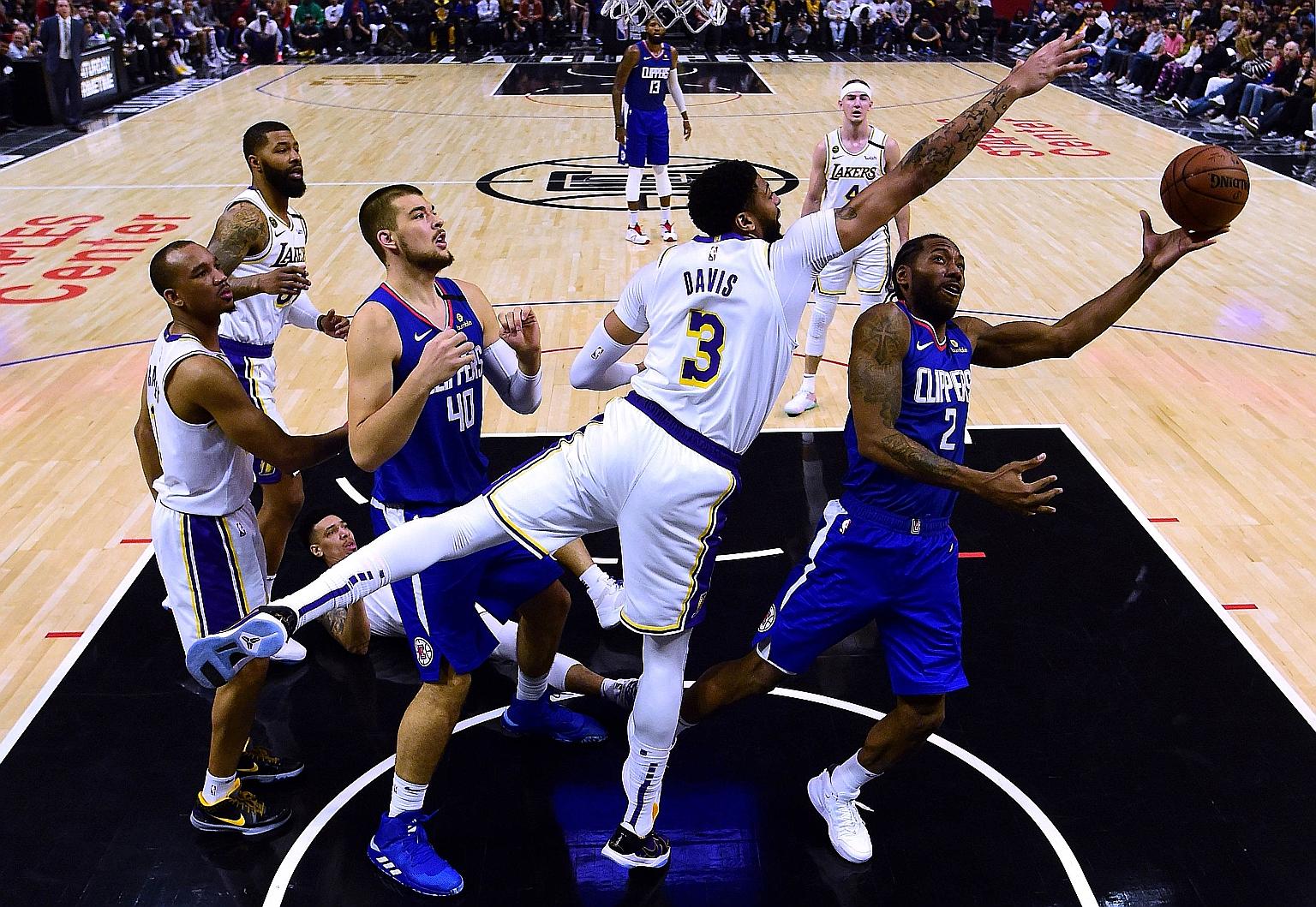 Clippers star Kawhi Leonard going to the basket under the close attention of Lakers' Anthony Davis of at the Staples Centre in March. Both Los Angeles teams will resume their season in Orlando if the NBA Players Association signs off on the restart p