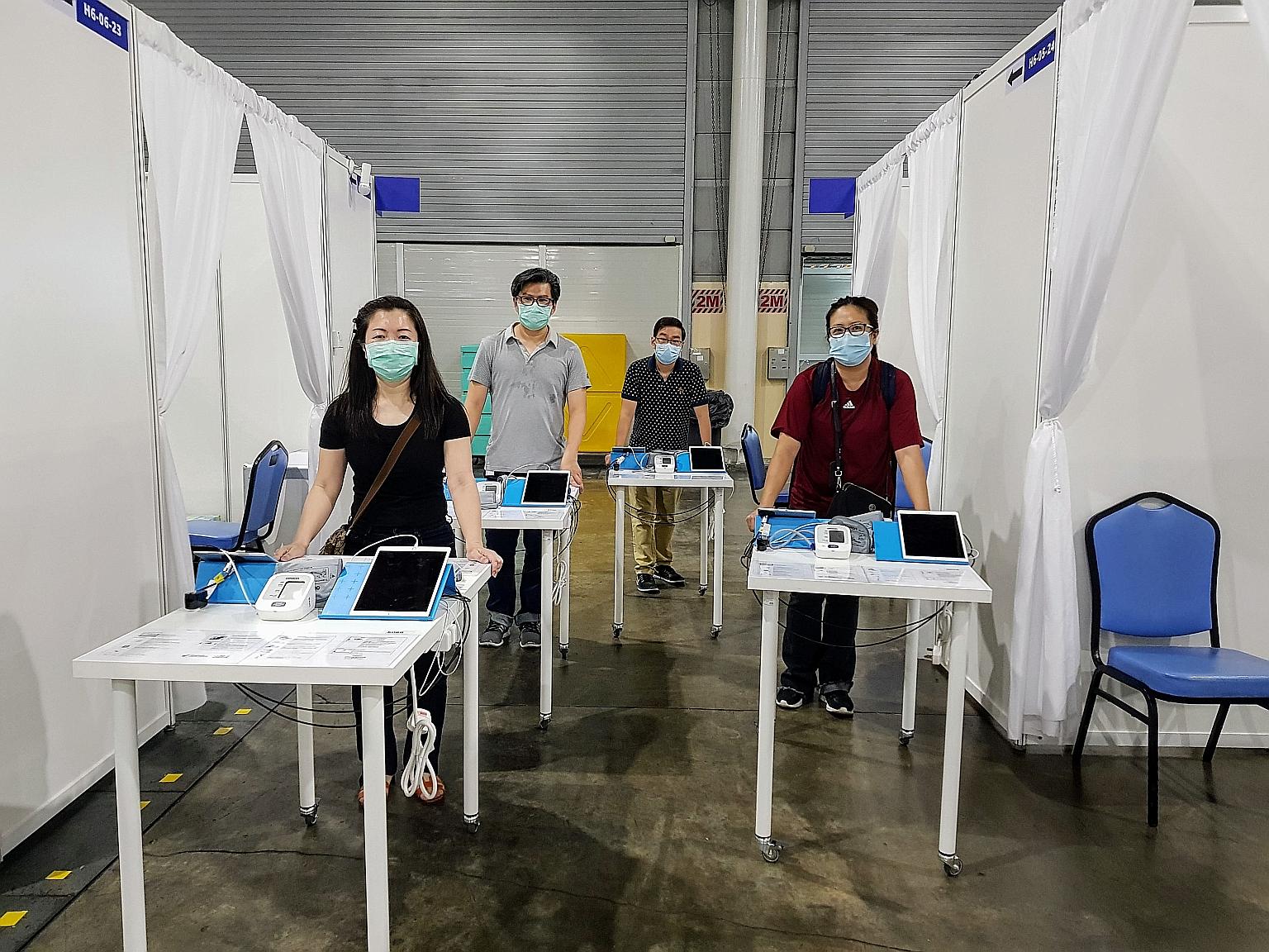 Integrated Health Information Systems staff with the mobile kiosks at Singapore Expo. The kiosks allow patients to take their own vital signs readings. PHOTO: IHIS