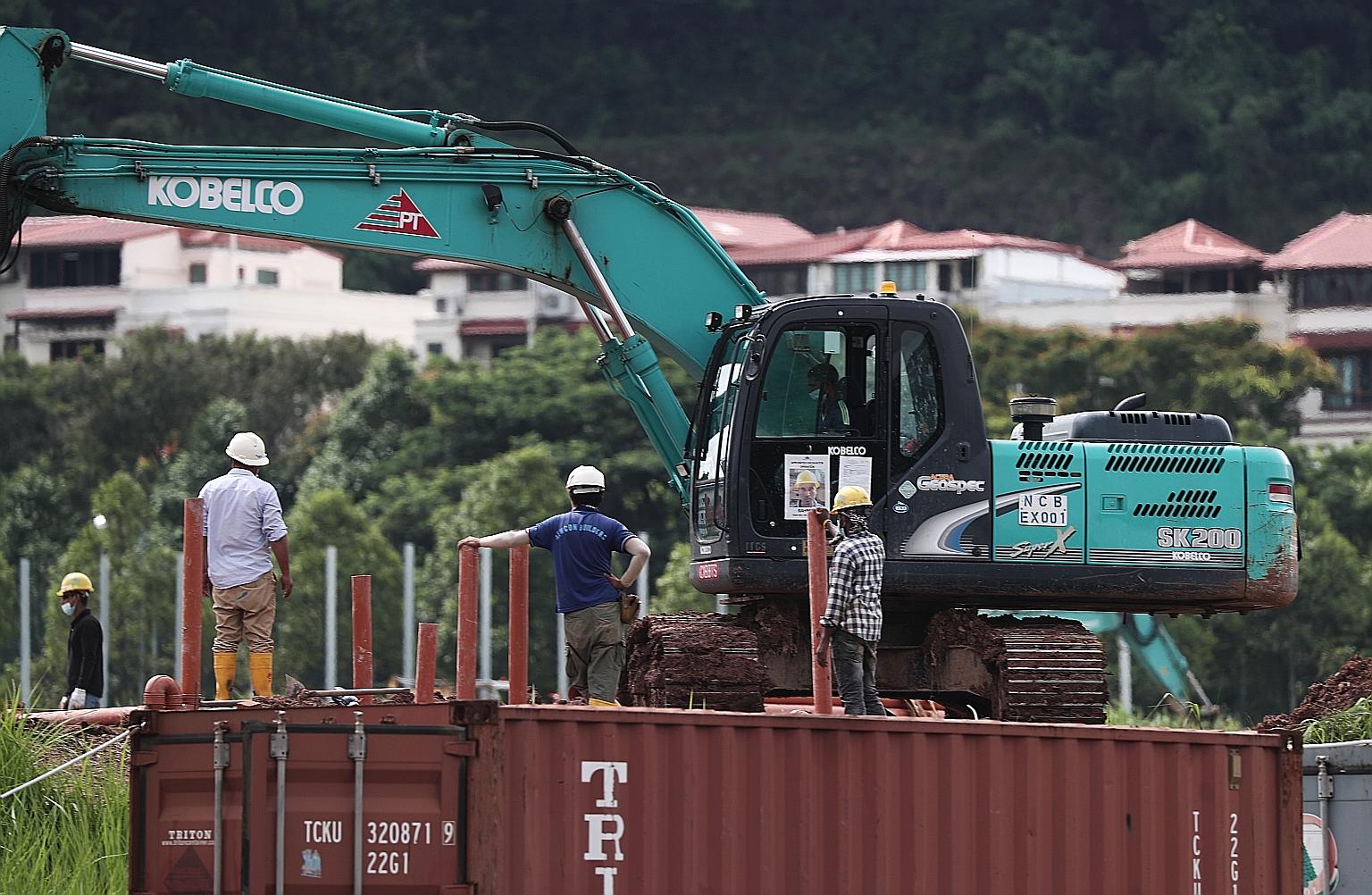 Workers at a site in Choa Chu Kang Grove yesterday. After consulting with the Health Ministry, the authorities will no longer require S-Pass and work permit holders in the construction sector who do not live in dormitories, work only in offices and d