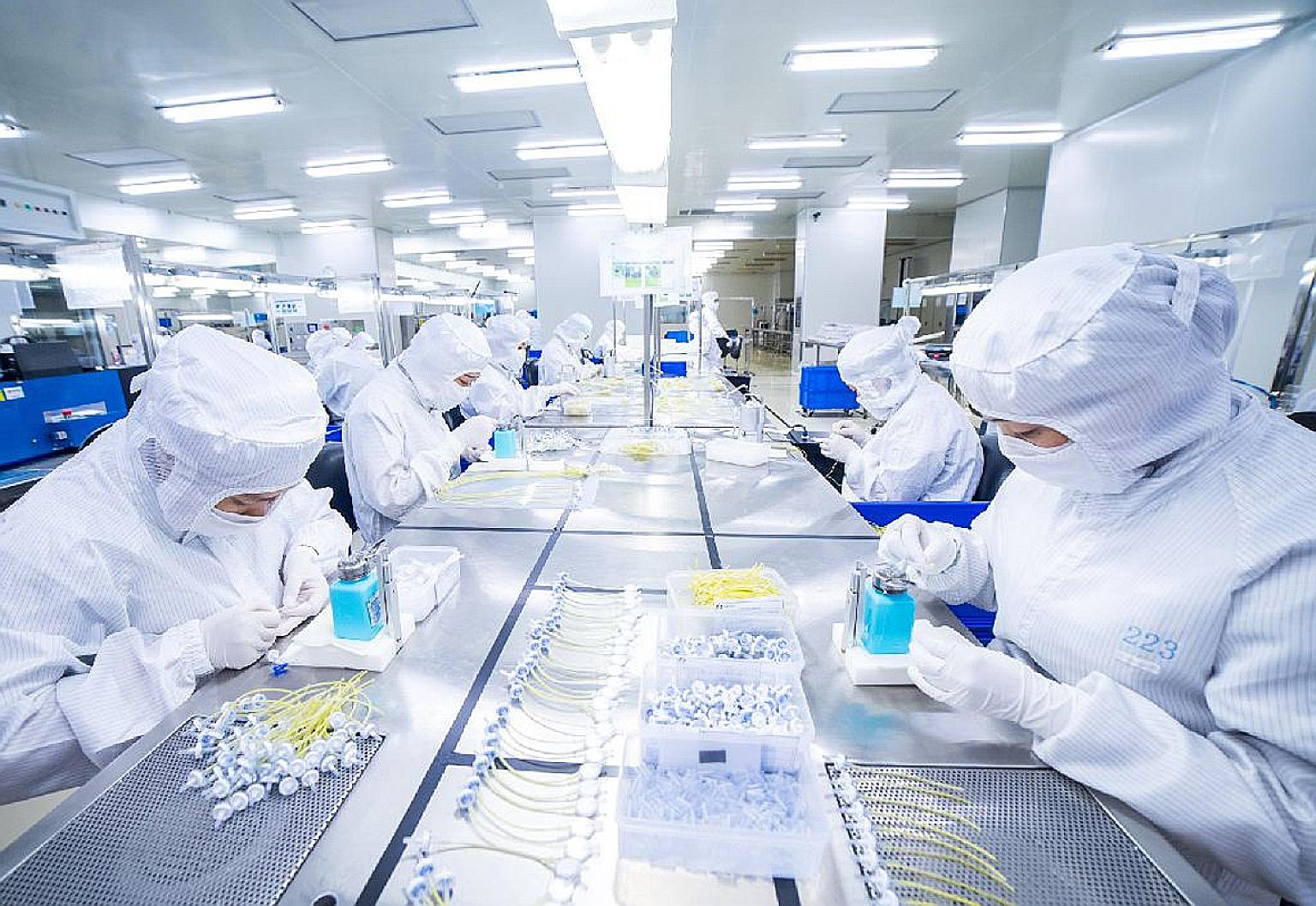 Employees assembling medical devices in a clean room in Forefront Medical's facility in Singapore. Among the five projects related to the coronavirus it has secured recently are test kit and nasal swab production.