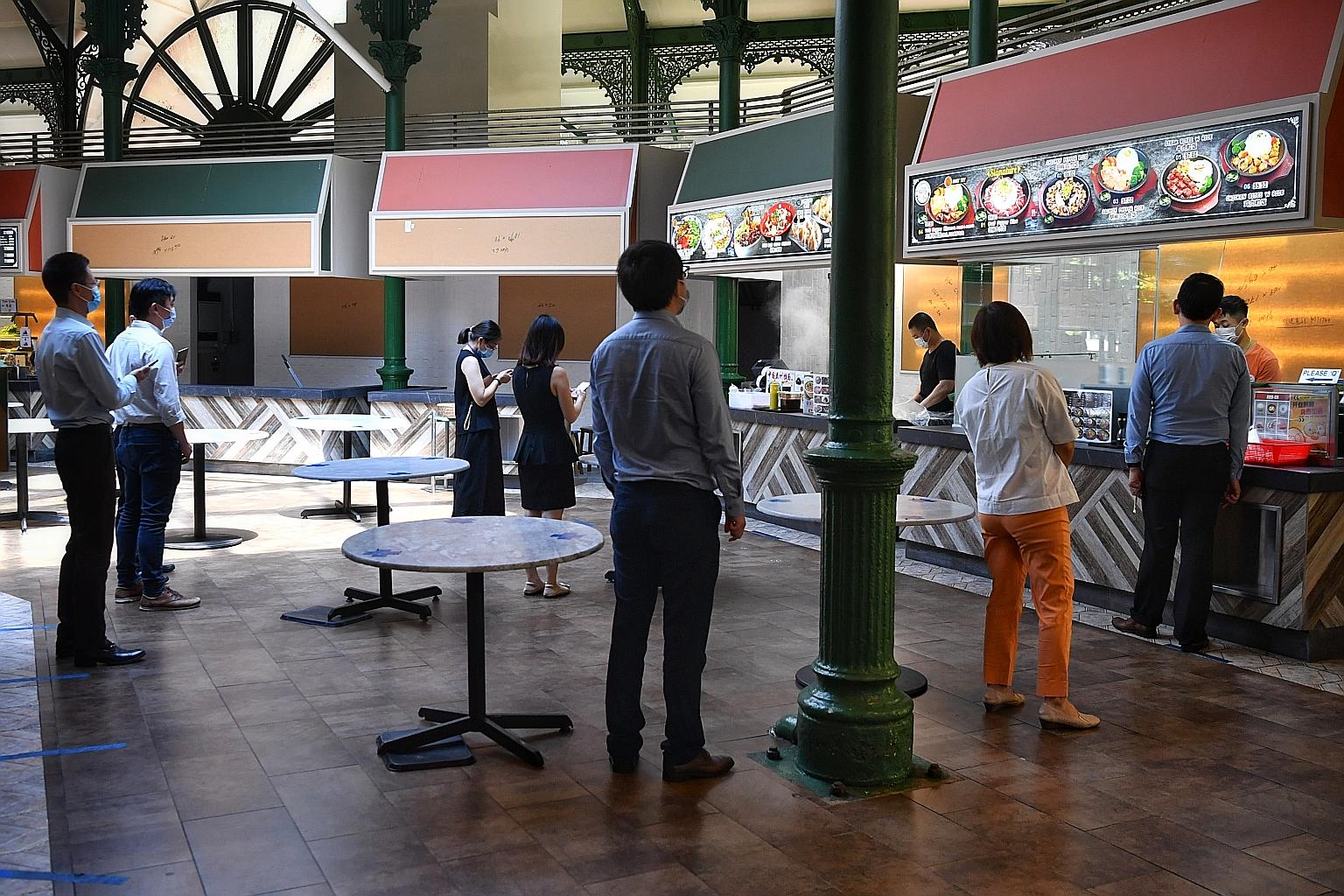 Customers queueing to buy food at Lau Pa Sat last week. Prime Minister Lee Hsien Loong urged Singaporeans to continue to play their part by maintaining personal hygiene, wearing masks when outside, keeping a safe distance from others and avoiding cro