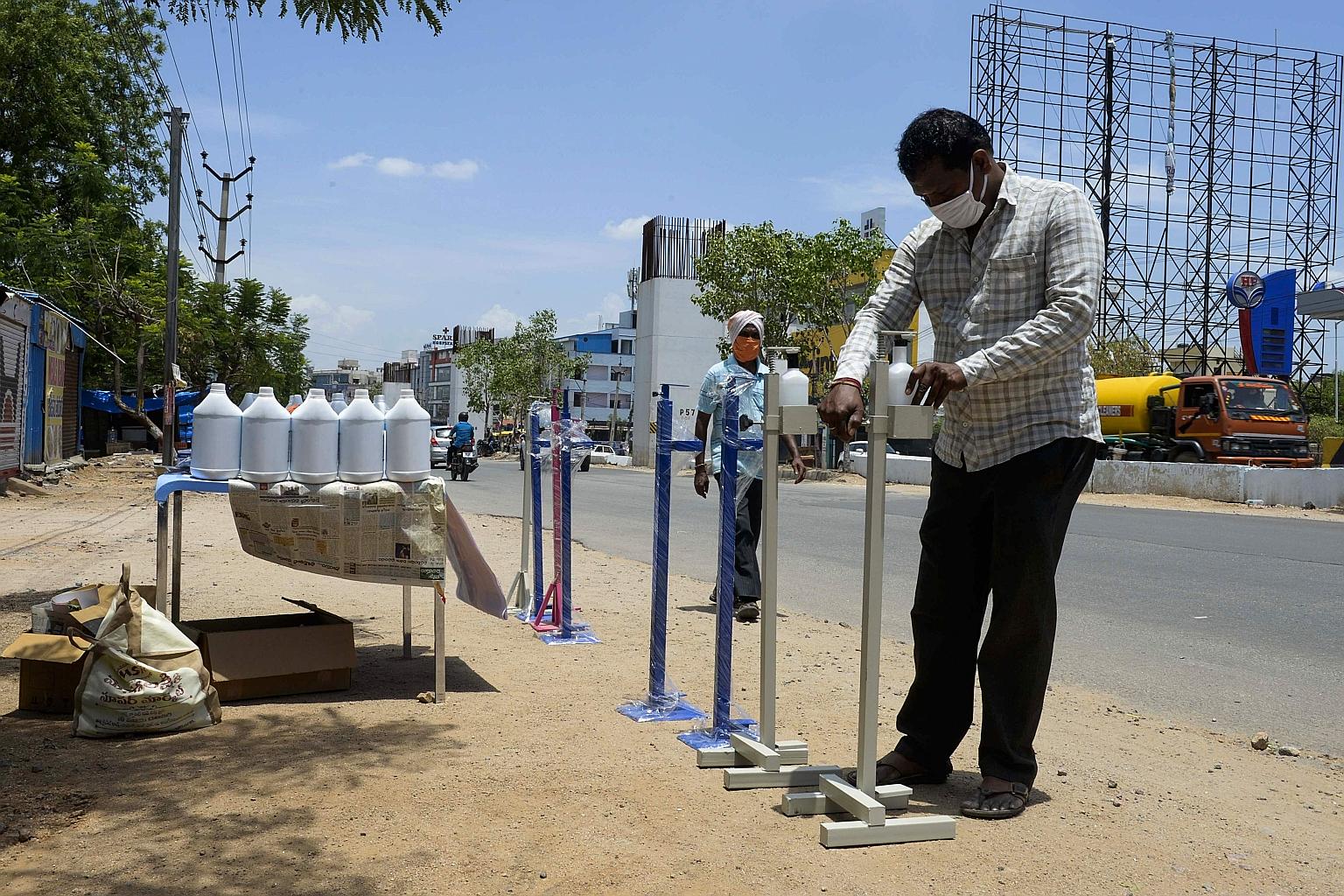 A vendor arranging containers with sanitiser on a street in the south Indian city of Hyderabad yesterday. The country is now easing a partial lockdown to allow millions of people to return to work.