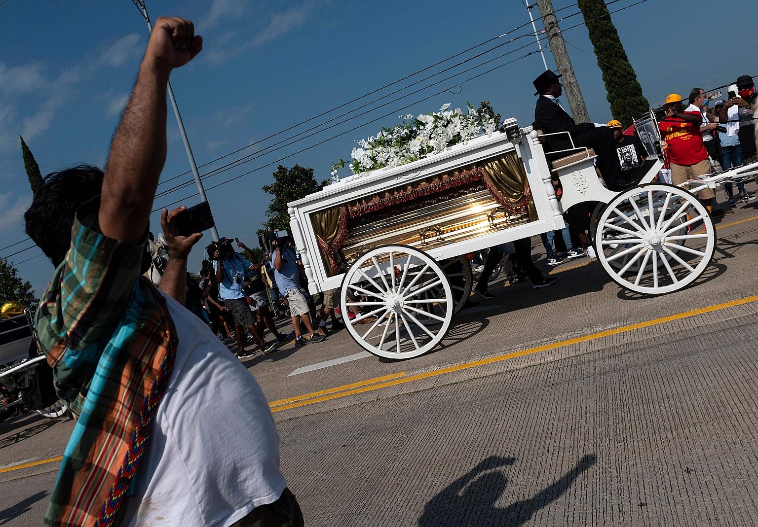 Mourners watching the casket of Mr George Floyd being carried by a horse-drawn carriage to his final resting place at the Houston Memorial Gardens cemetery in Texas on Tuesday. Mr Floyd, a black man, died after a white police officer knelt on his nec