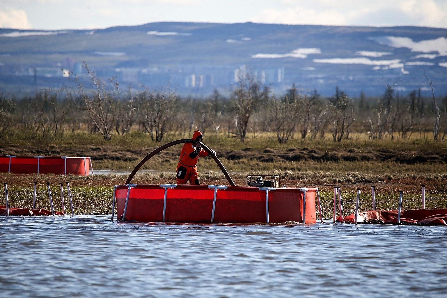 A worker from the Russian emergency ministry doing intervention work at a river outside Norilsk. The diesel fuel spill has spread to a lake near the Arctic Ocean. President Vladimir Putin last week declared a state of emergency after it became clear 